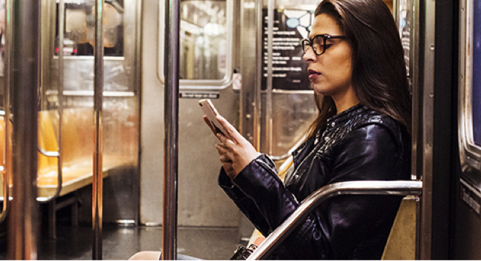 A woman sitting on a train using her mobile phone