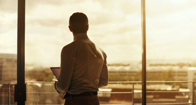 man looking out window