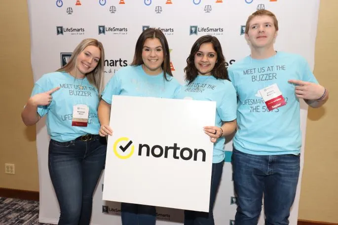 National LifeSmarts Championship attendees hold up a sign with a Norton logo on it